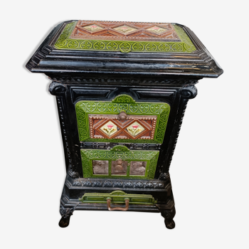 Wood stove in black and green cast iron, decoration of earthenware tiles Chardons.