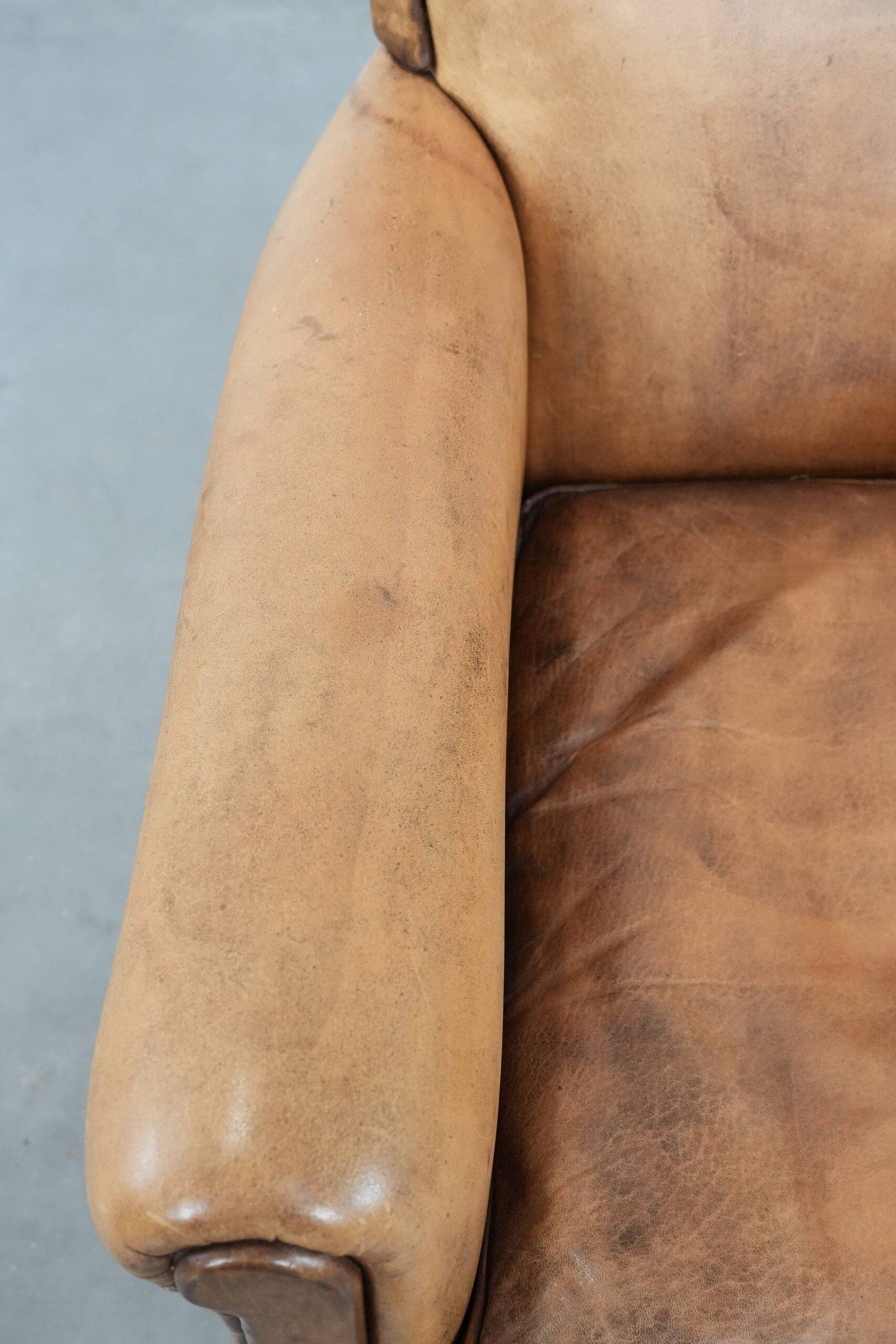 Vintage sheepskin armchair with a beautiful light colour and elegant legs