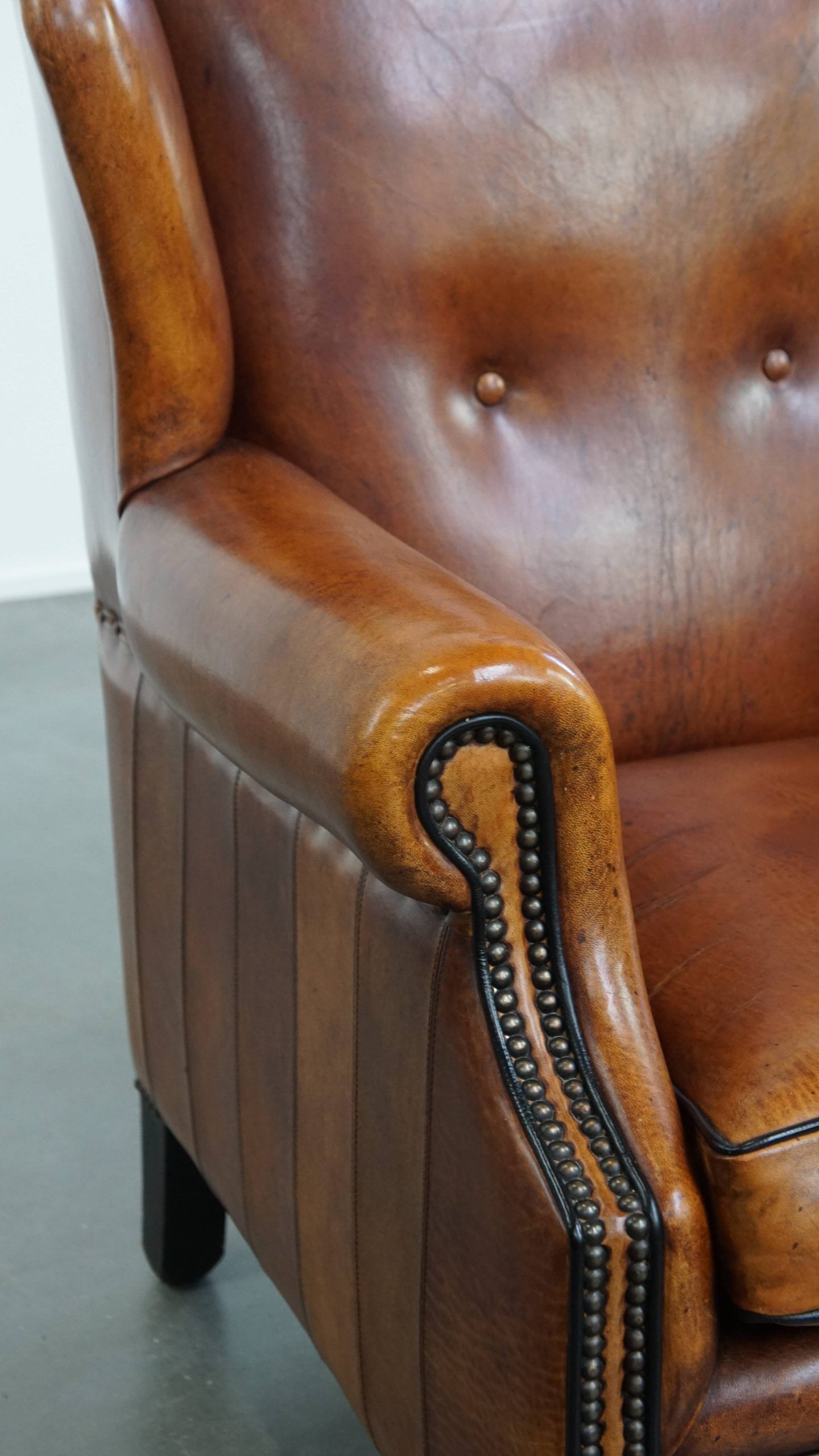 Sheepskin wingback armchair with stitching and black piping