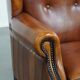 Sheepskin wingback armchair with stitching and black piping