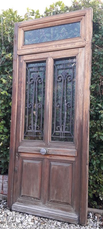 Oak entrance door and its frame and transom, wrought iron gates