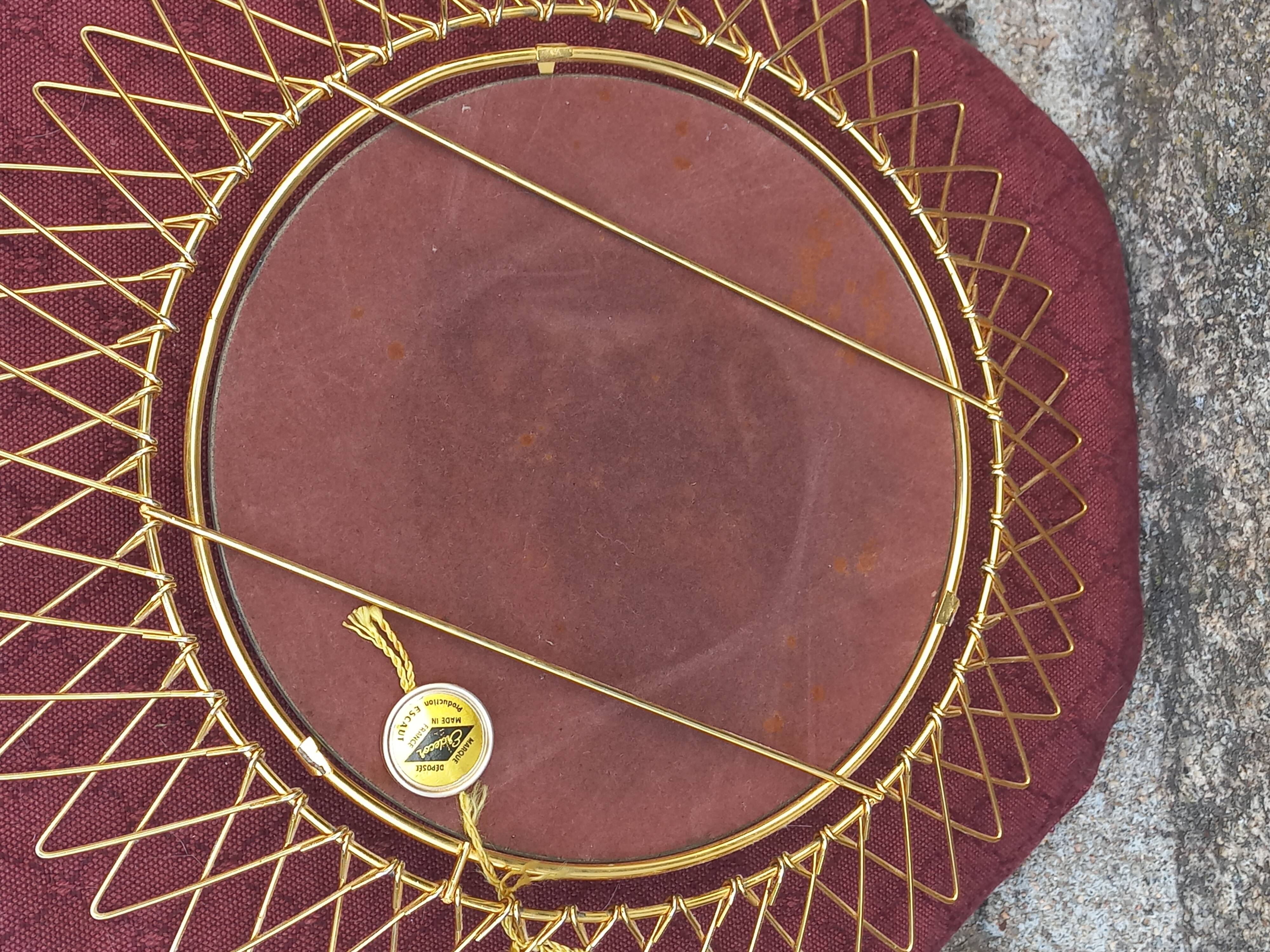 Vintage 1950s sun mirror in gold metal.