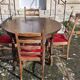 Round wooden table with 1 integrated extension + 6 wooden and fabric chairs