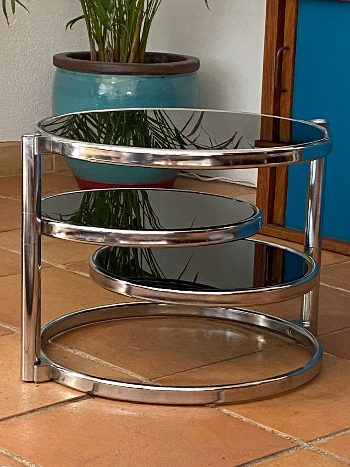 Coffee table with pivoting metal and black glass elements.