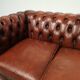 Two-seater brown leather chesterfield sofa