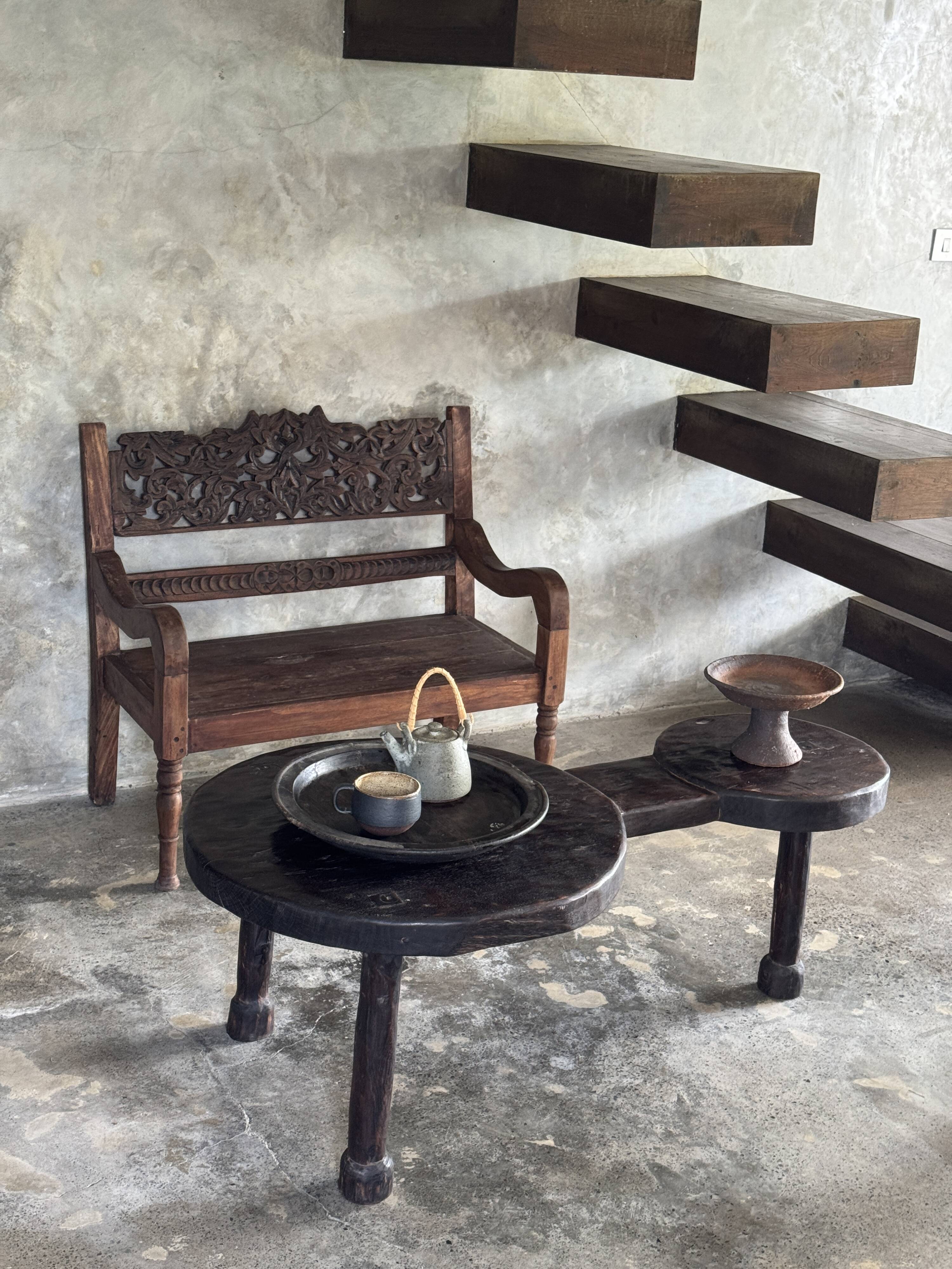 Small antique Indonesian bench in carved teak with plant and floral motifs.