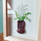 Composition d'un bouquet des muguets dans un pot en argile en forme the chaussure