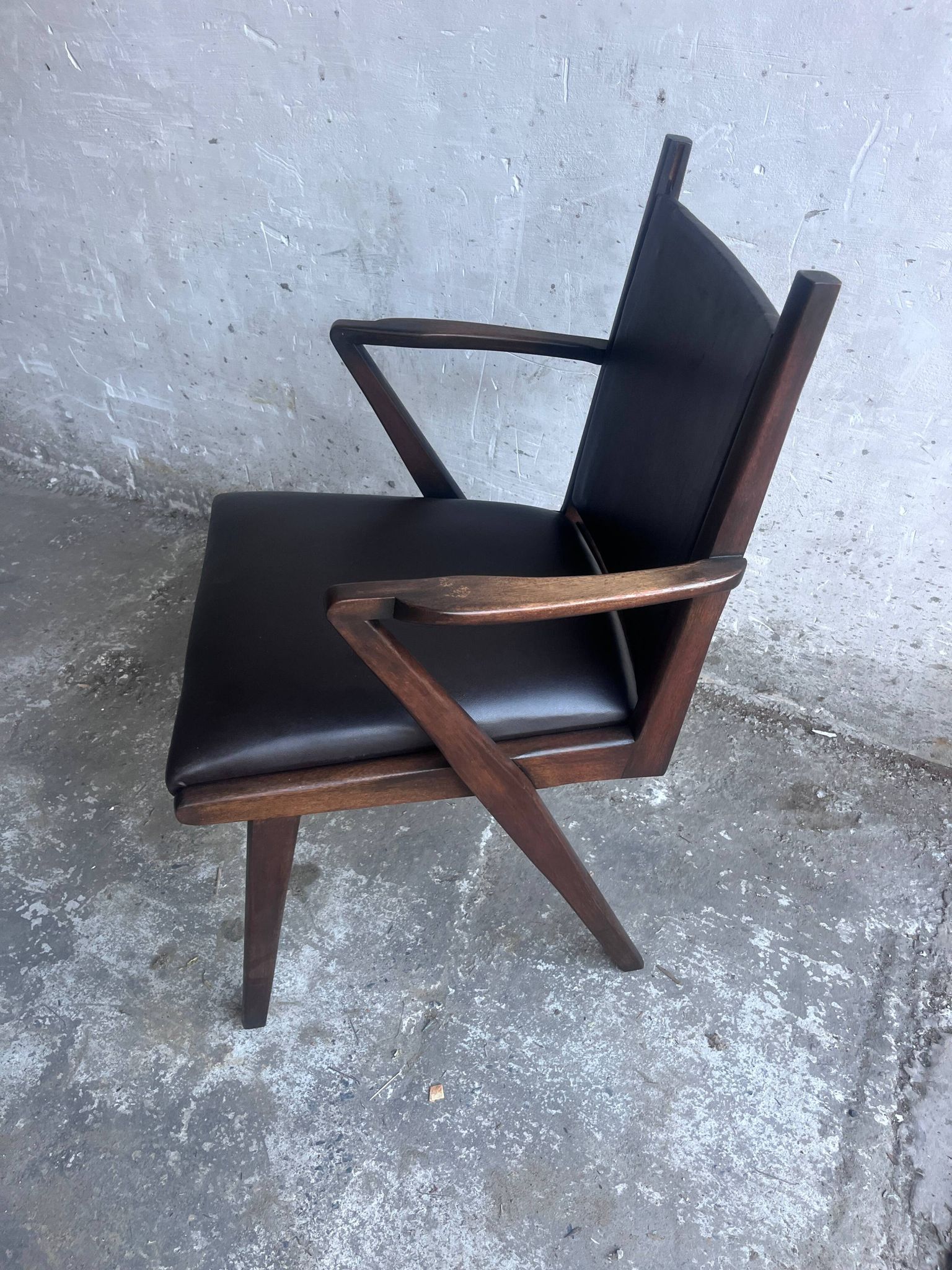 Pair of sculptural mid-century armchairs in dark wood and brown upholstery.