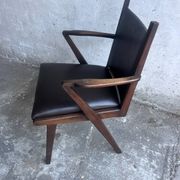 Pair of sculptural mid-century armchairs in dark wood and brown upholstery.