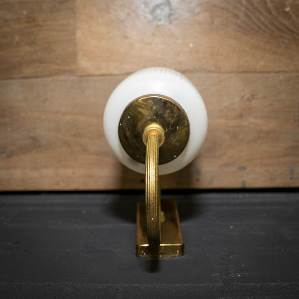 Ornate wall lamp made of milk glass and brass