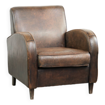 Comfortable sheepskin armchair with matching piping and a timeless look