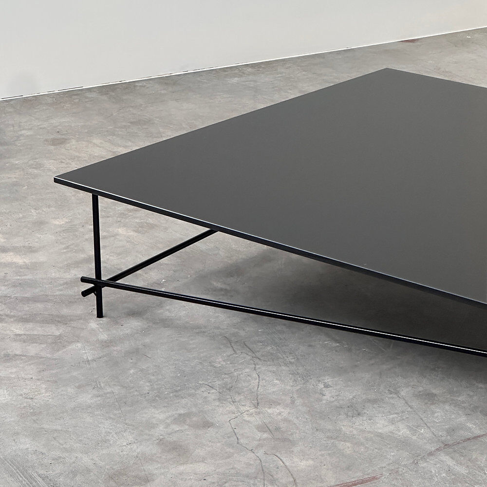 Minimalist black glass coffee table with industrial metal base