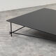 Minimalist black glass coffee table with industrial metal base
