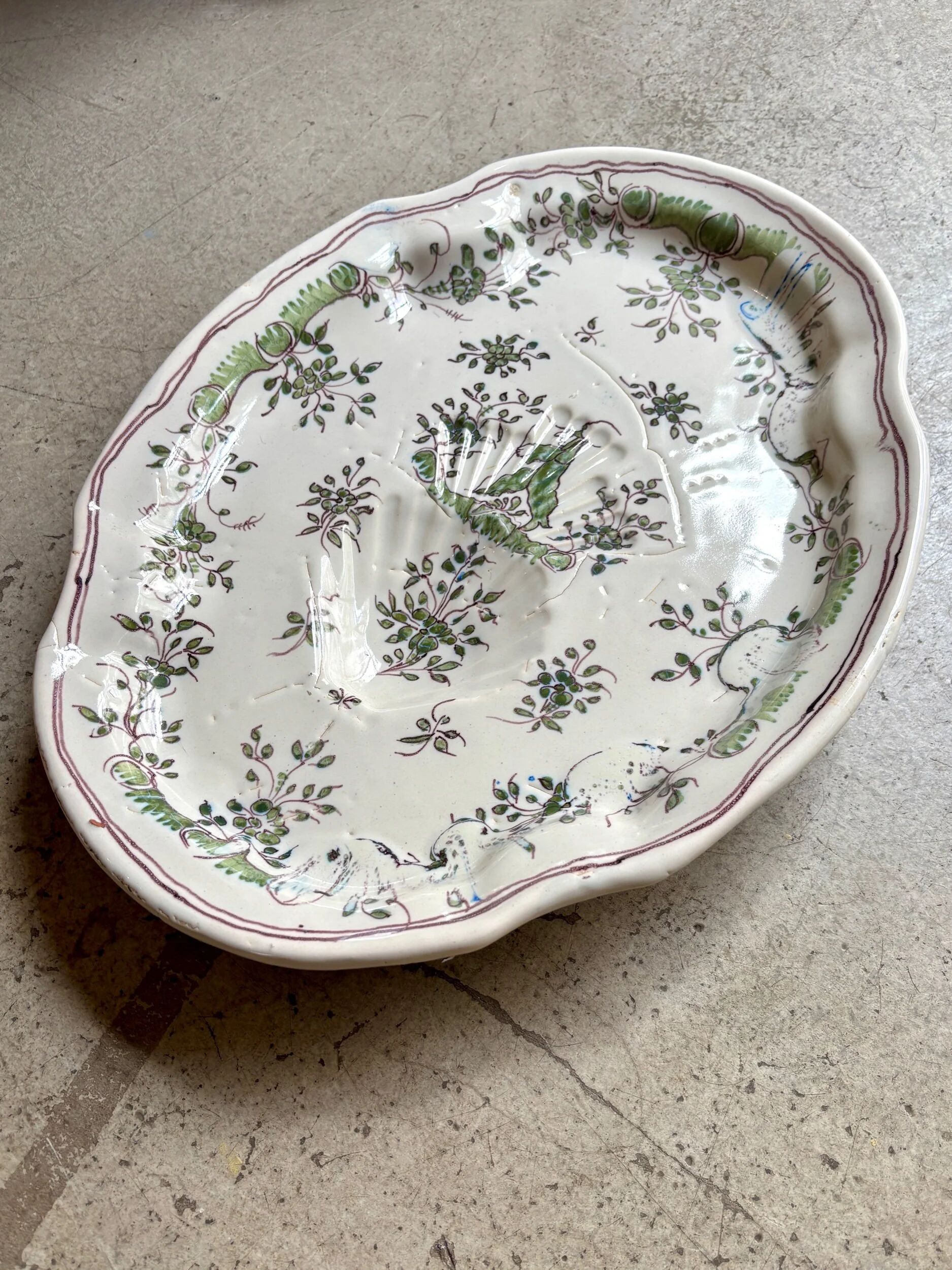 Oval Moustiers plate in cream and green earthenware, 18th century.