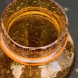 Blown and bubbled glass jar in the style of Biot glassworks, amber color