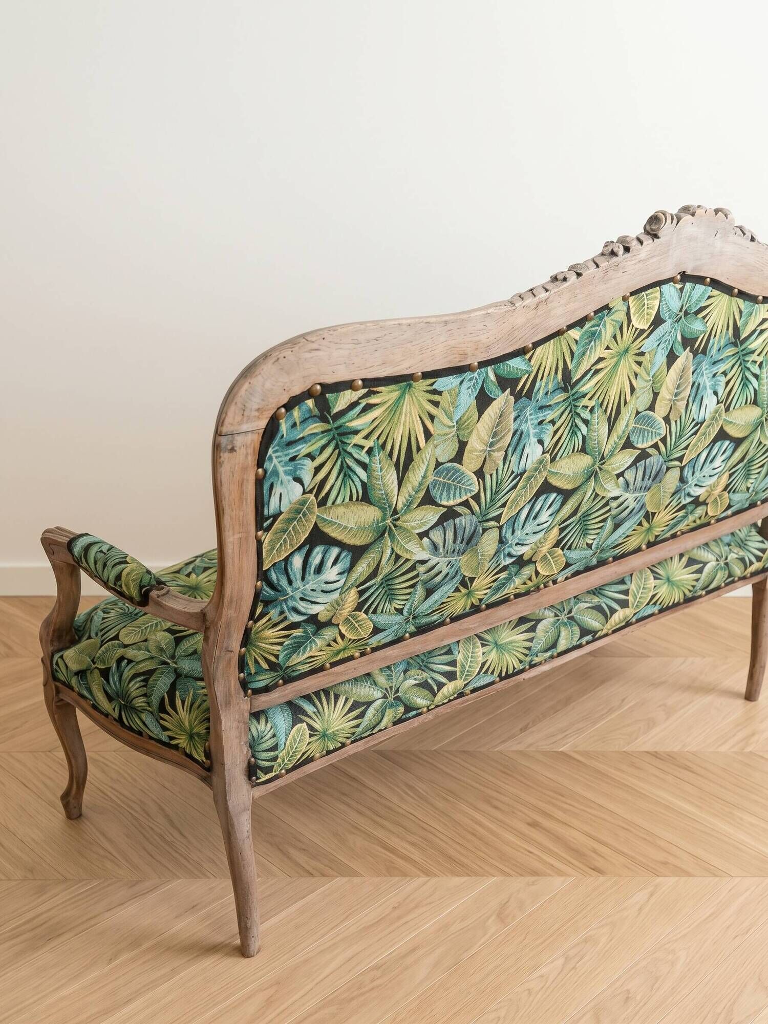 Louis XV bench reupholstered with a green tropical pattern.