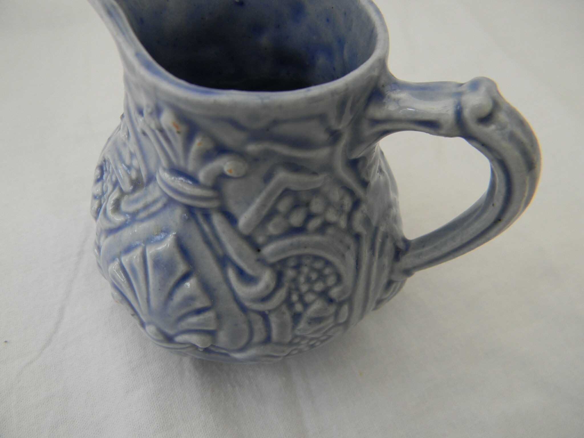Petit pot à lait bleu en barbotine.