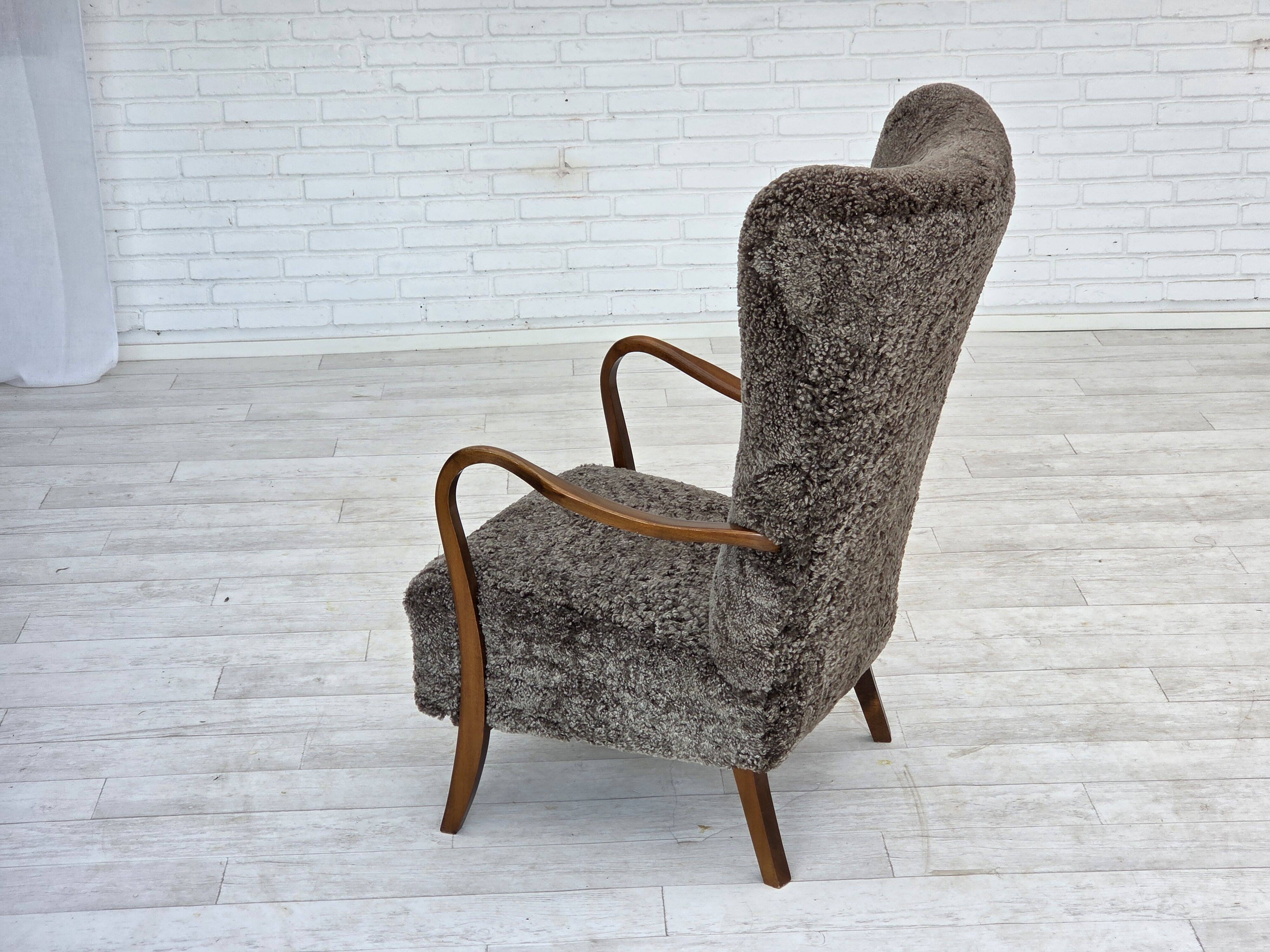1960s, reupholstered Danish armchair, with stool, genuine sheepskin.