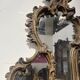 Mirror with a decorative frame featuring a four-light wall sconce, 19th century.