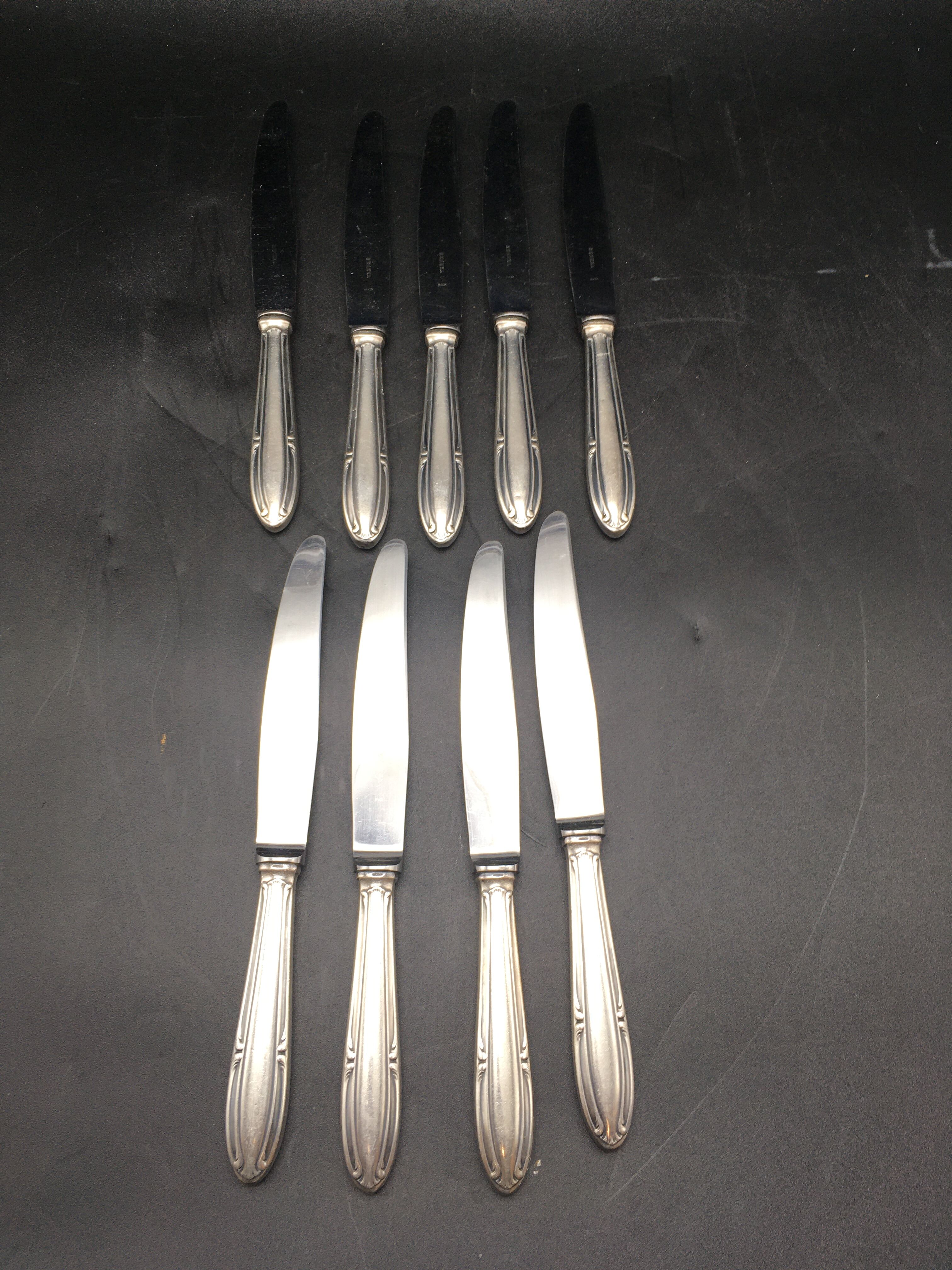 9 table knives in silver metal.
