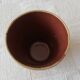 Mustard-colored ceramic cup or glass with green decor
