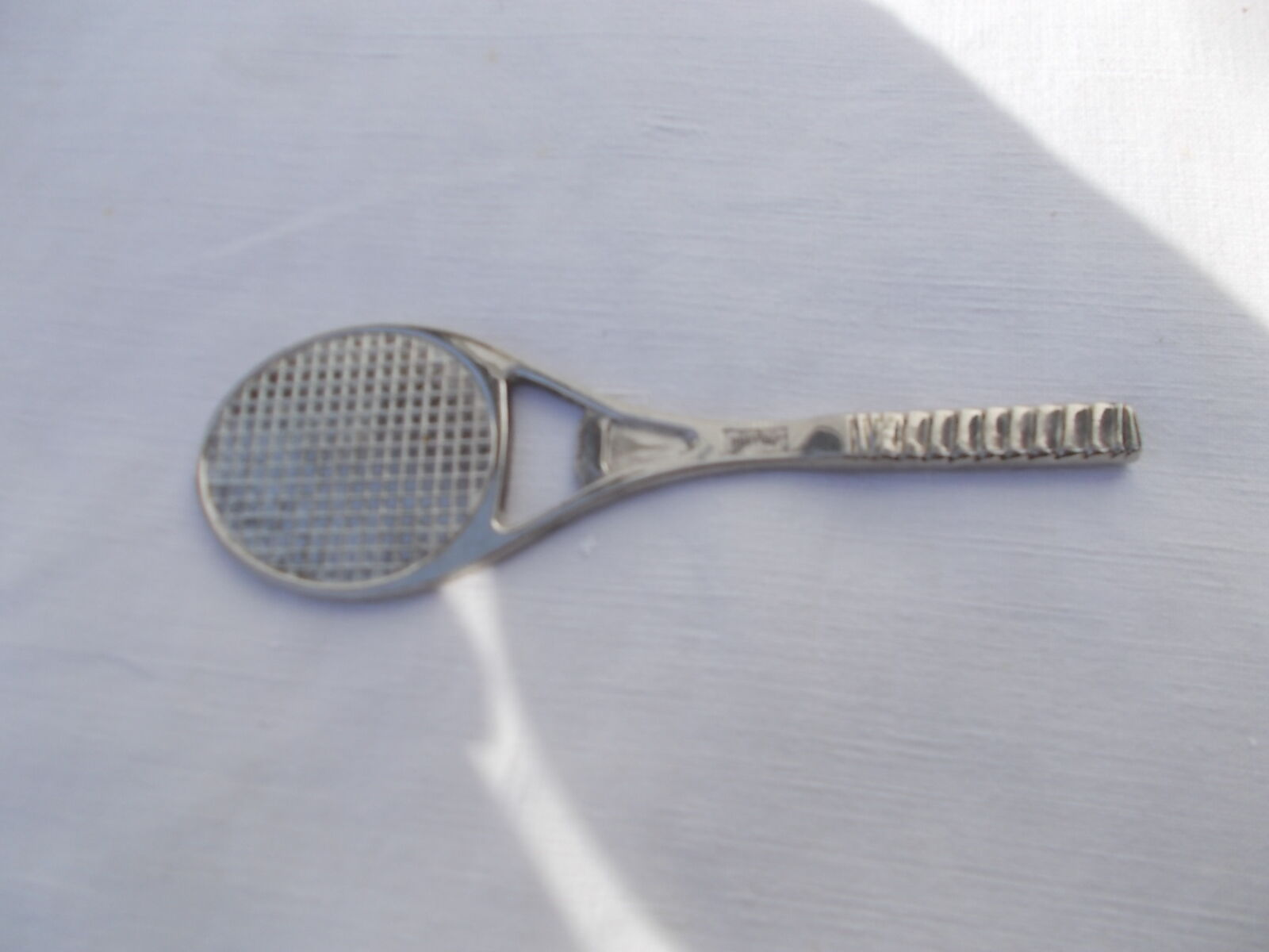 Décapsuleur en métal argenté forme raquette