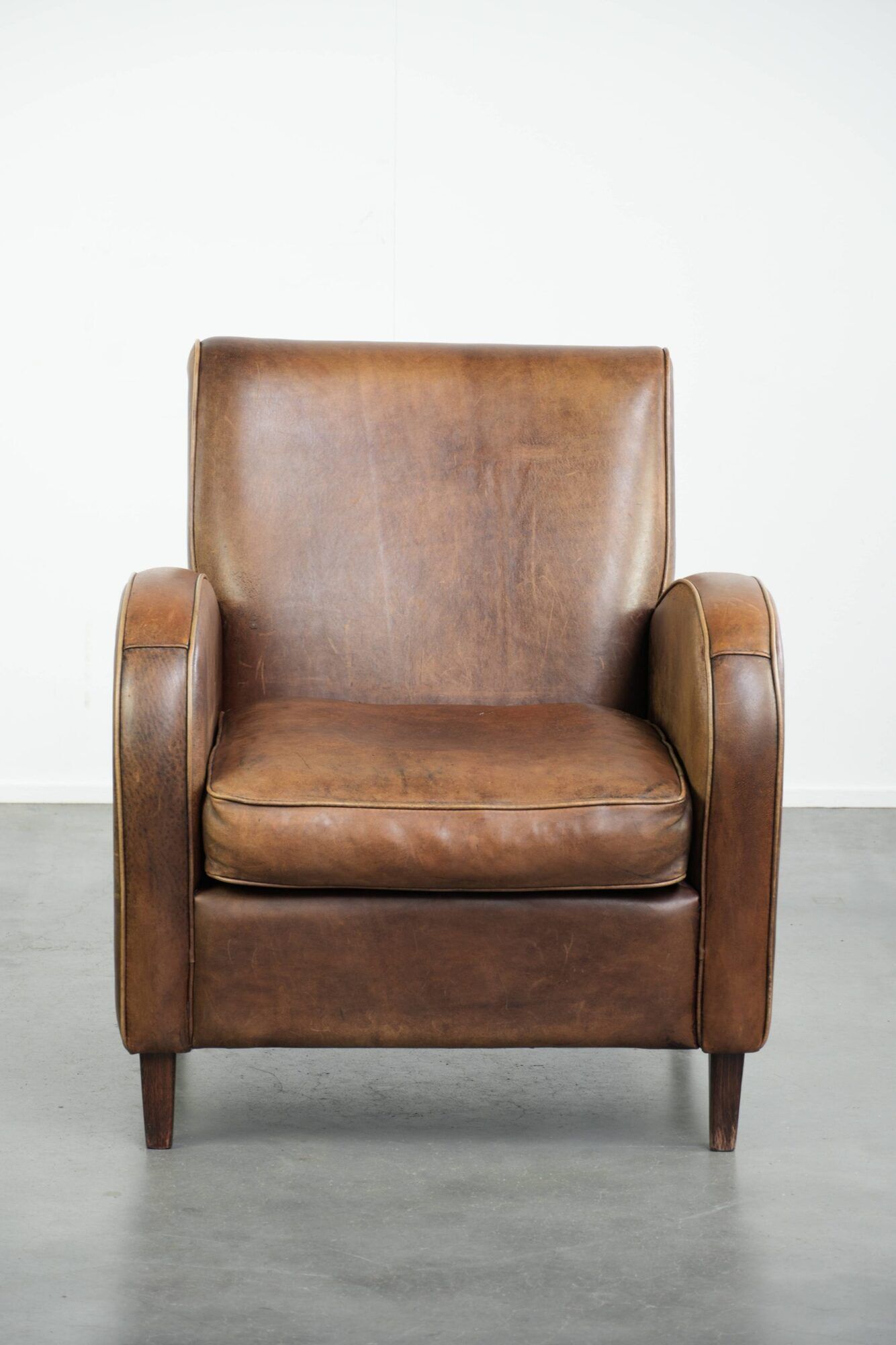 Sheepskin armchair in a light cognac colour with matching piping