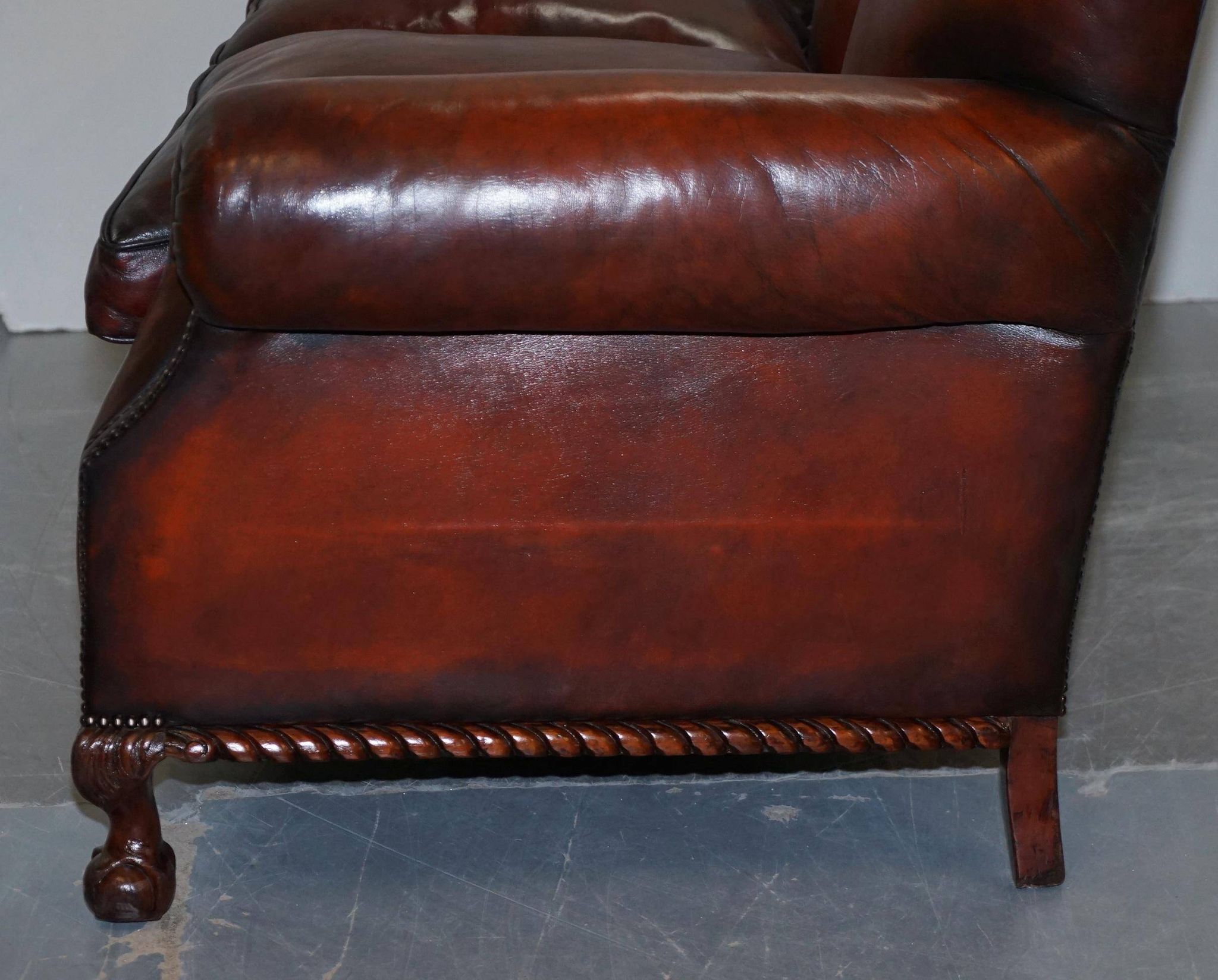 Restored Victorian sofa in leather with claw feet and feather cushions.