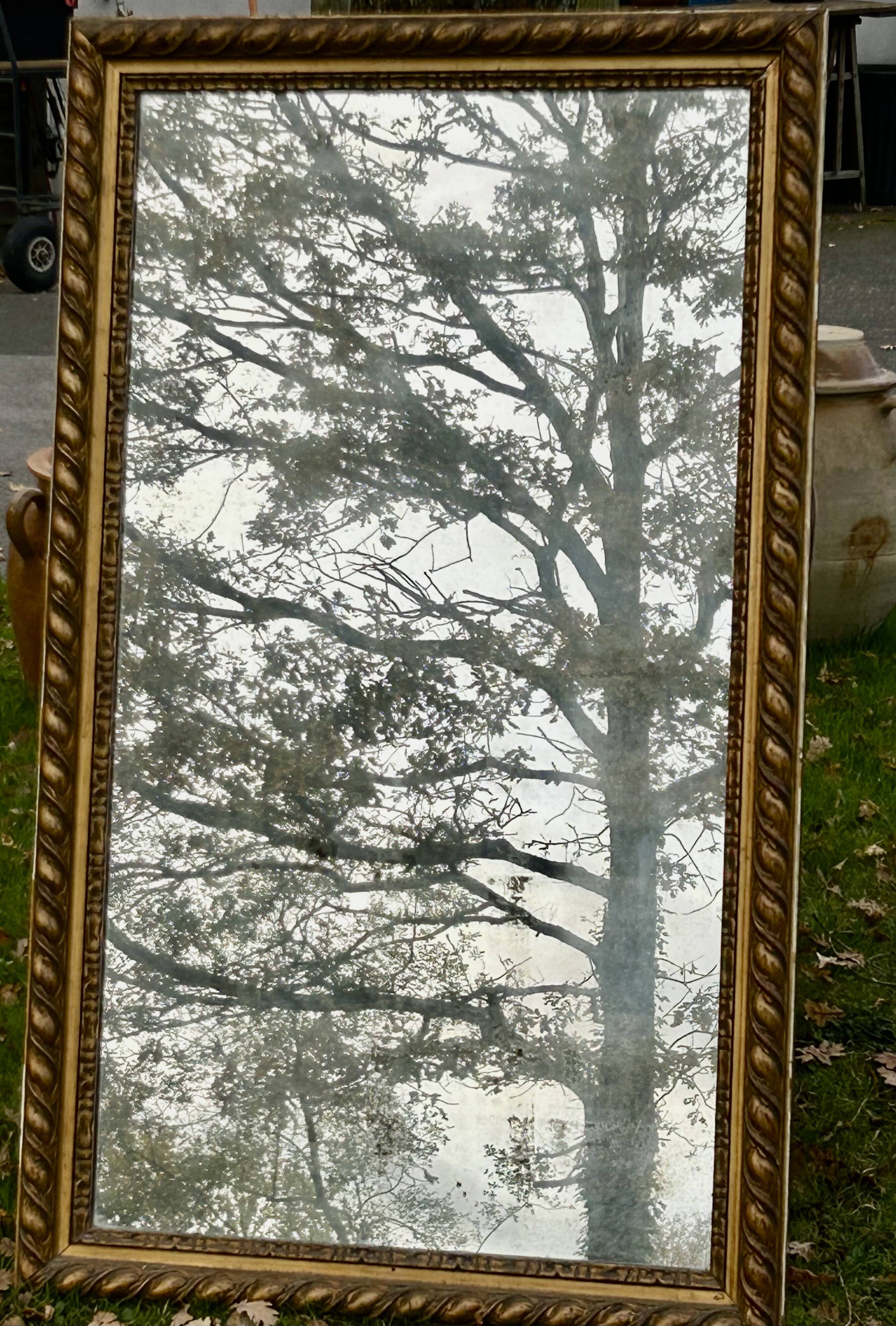 Large antique gilded mirror, wood and stucco gadroons, partially de-mercury