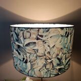 Table lamp with chrome stem, tropical plant shade.