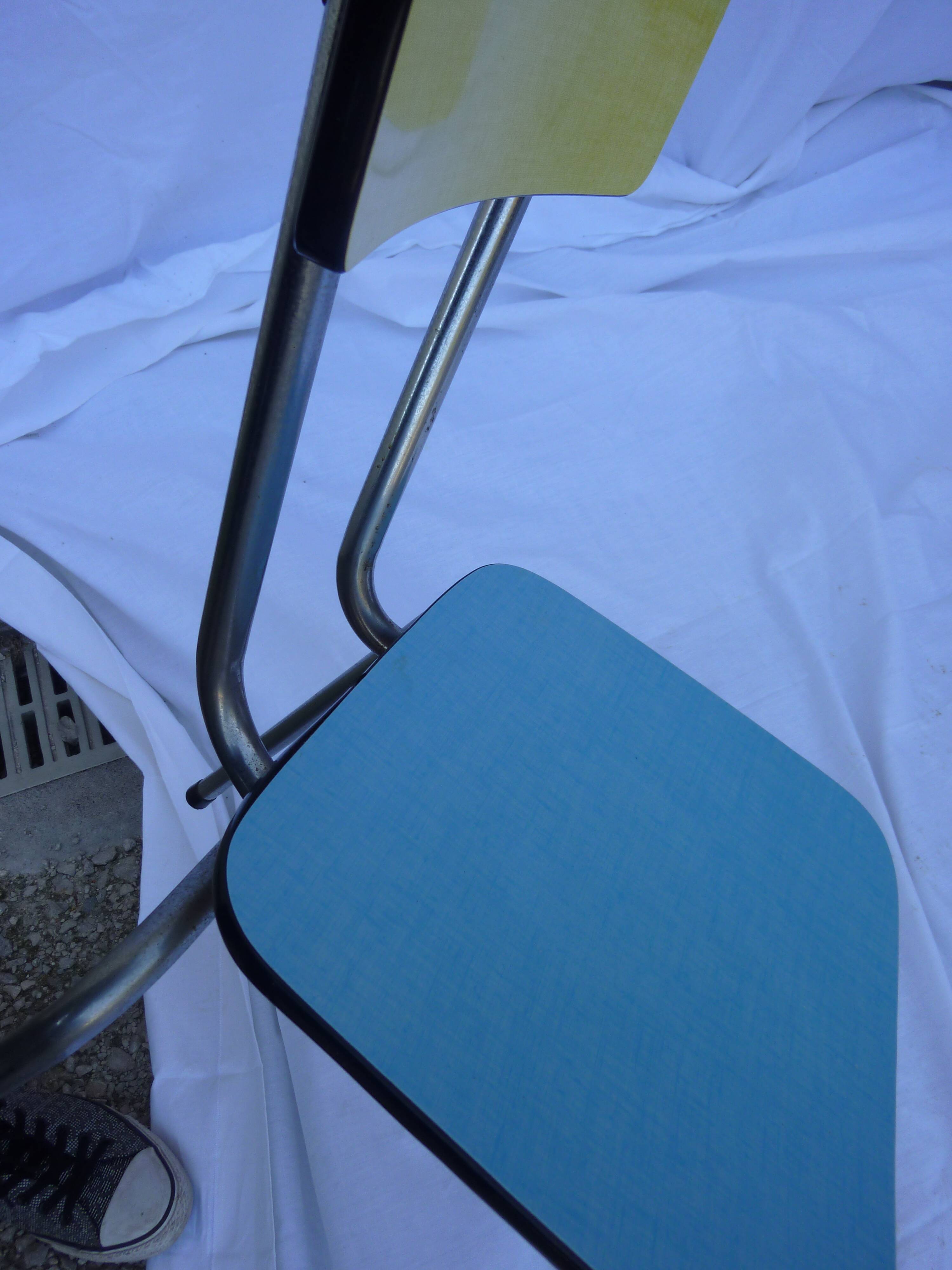 Two chairs and a yellow and blue stool in formica