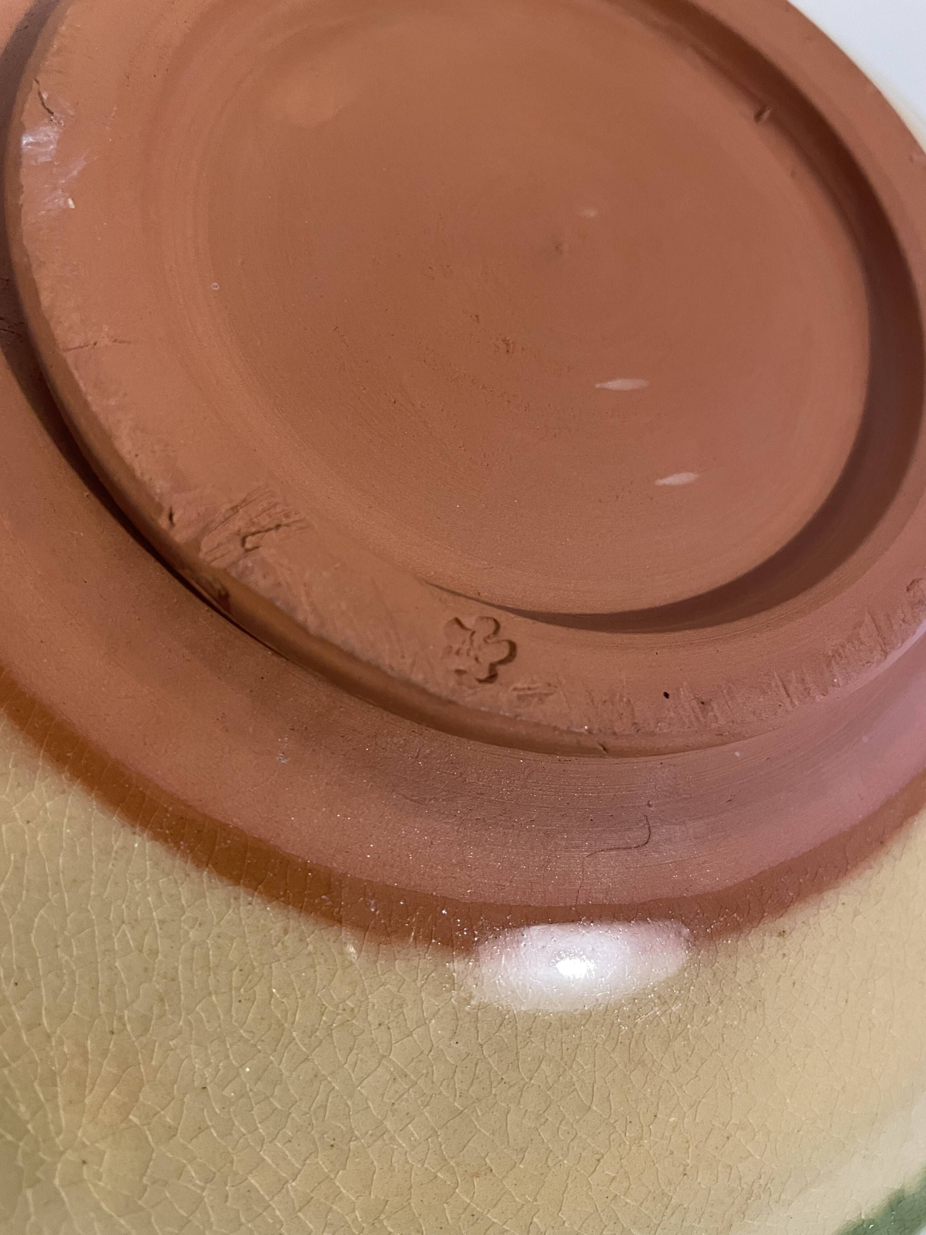 Decorative glazed terracotta plate with olive leaf pattern.