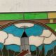 Art Deco stained glass window decorated with a 20th century church steeple