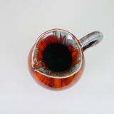 Large red and blue glazed ceramic pitcher signed Delène under the base