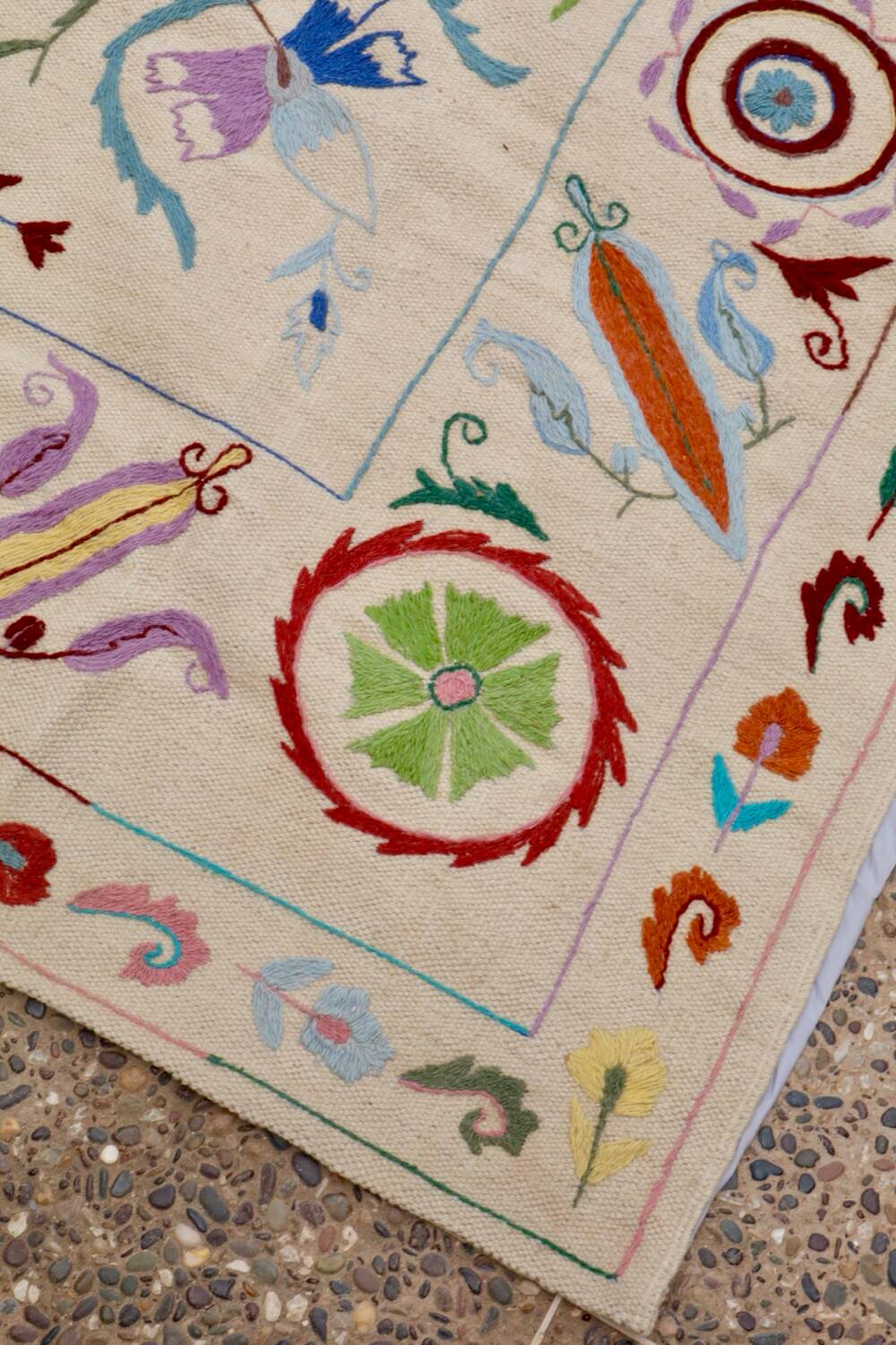 White suzani kilim rug with embroidered multi-colored patterns