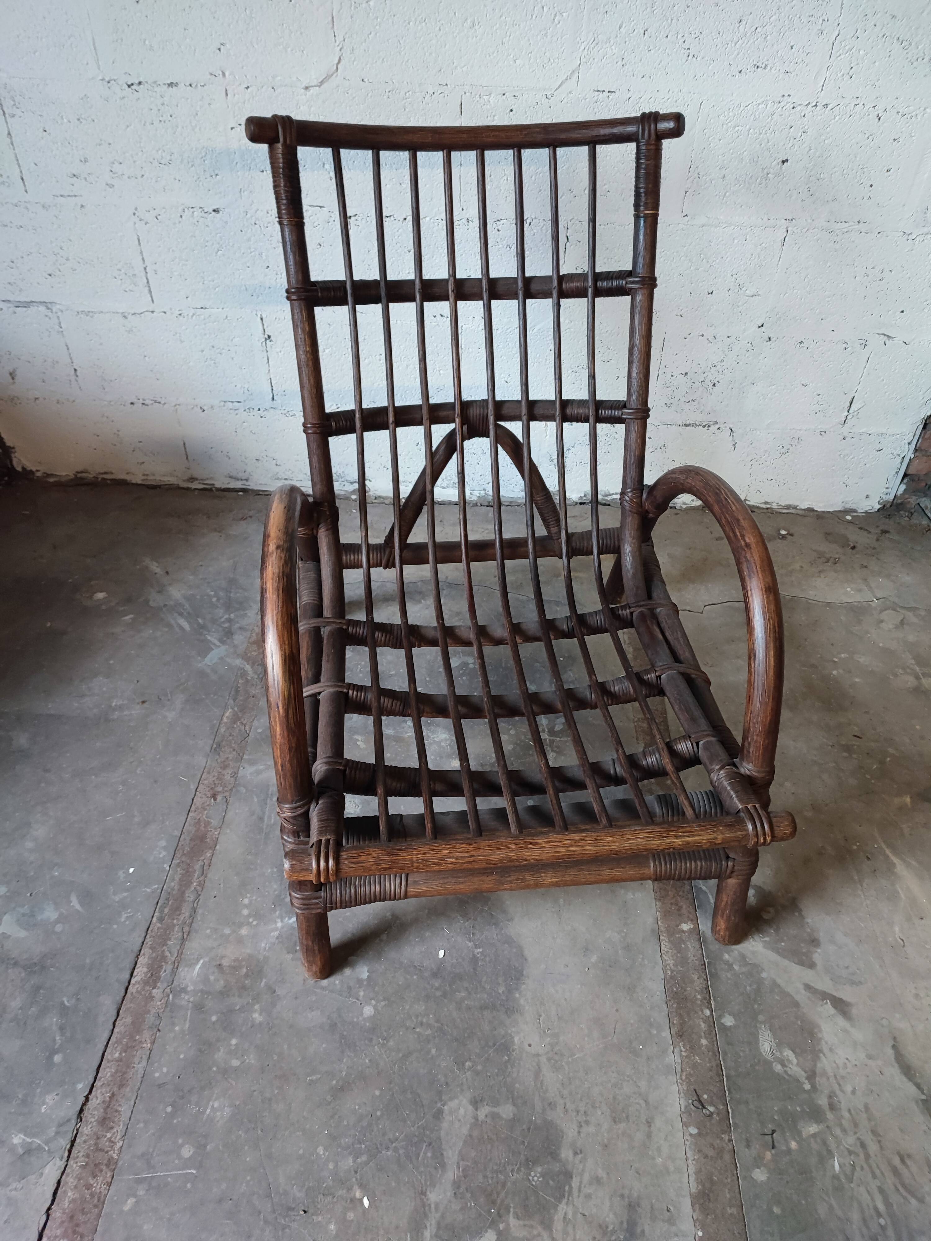 Relaxed armchair in bamboo and rattan with its small side table. Beige linen cushion.