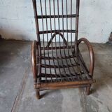 Relaxed armchair in bamboo and rattan with its small side table. Beige linen cushion.