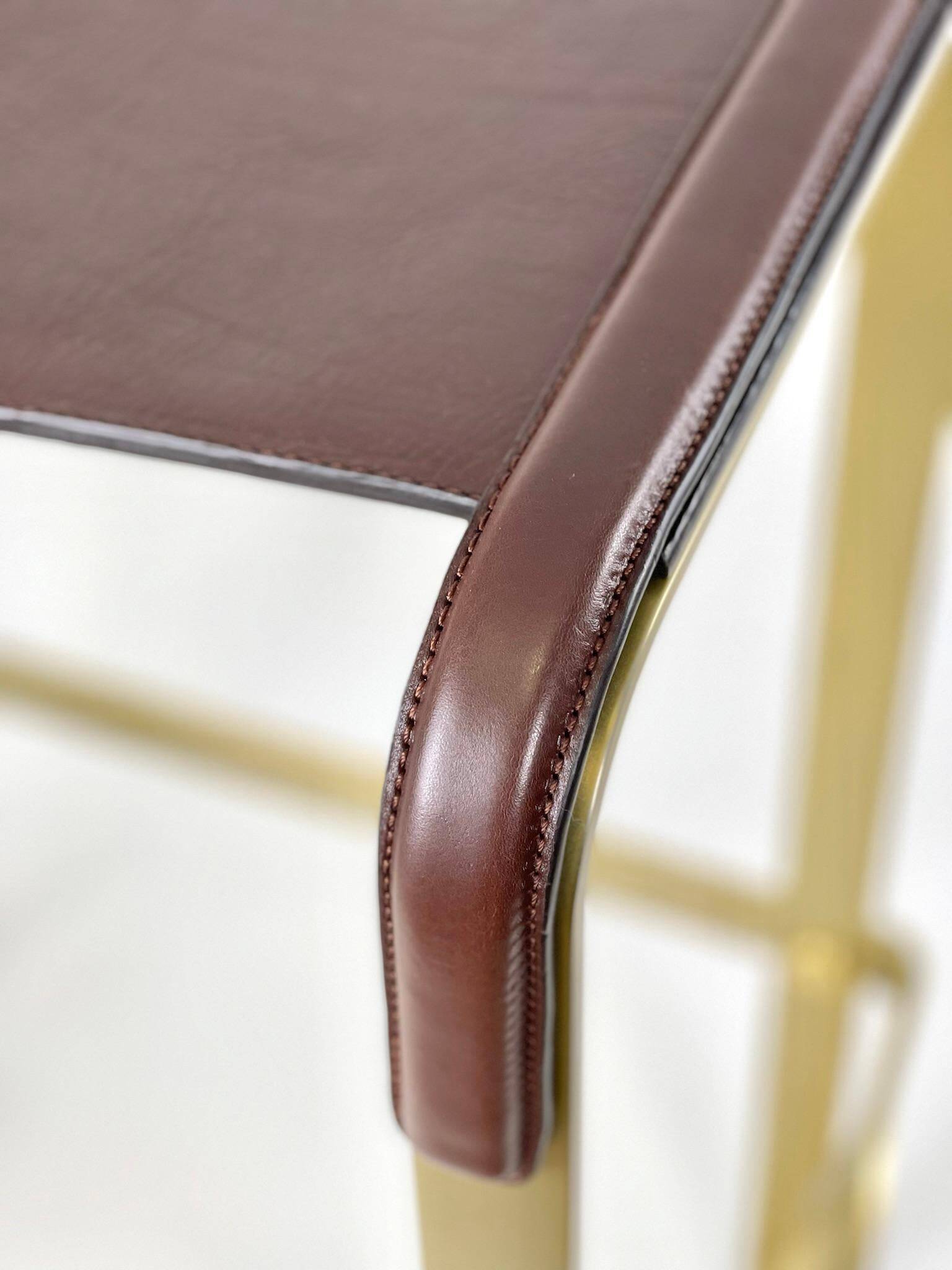 Contemporary kitchen stool, aged brass metal and cognac leather.