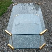 1970s designer coffee table in glass, plexiglass, and gold metal.