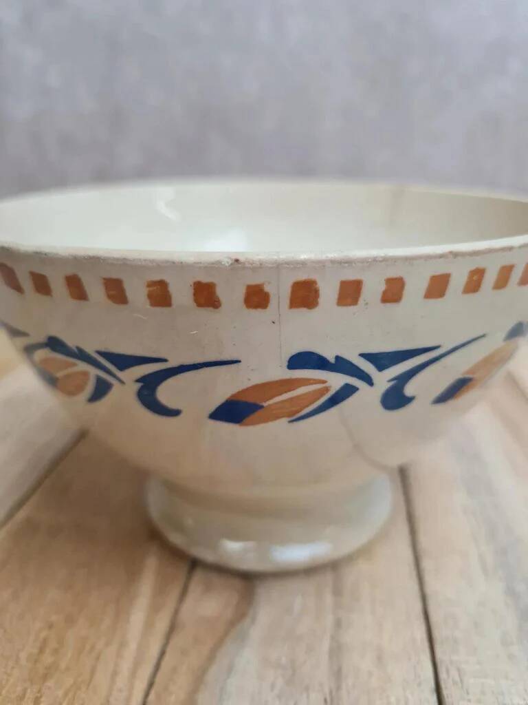 Old ironstone bowl with vintage blue and ochre decoration.