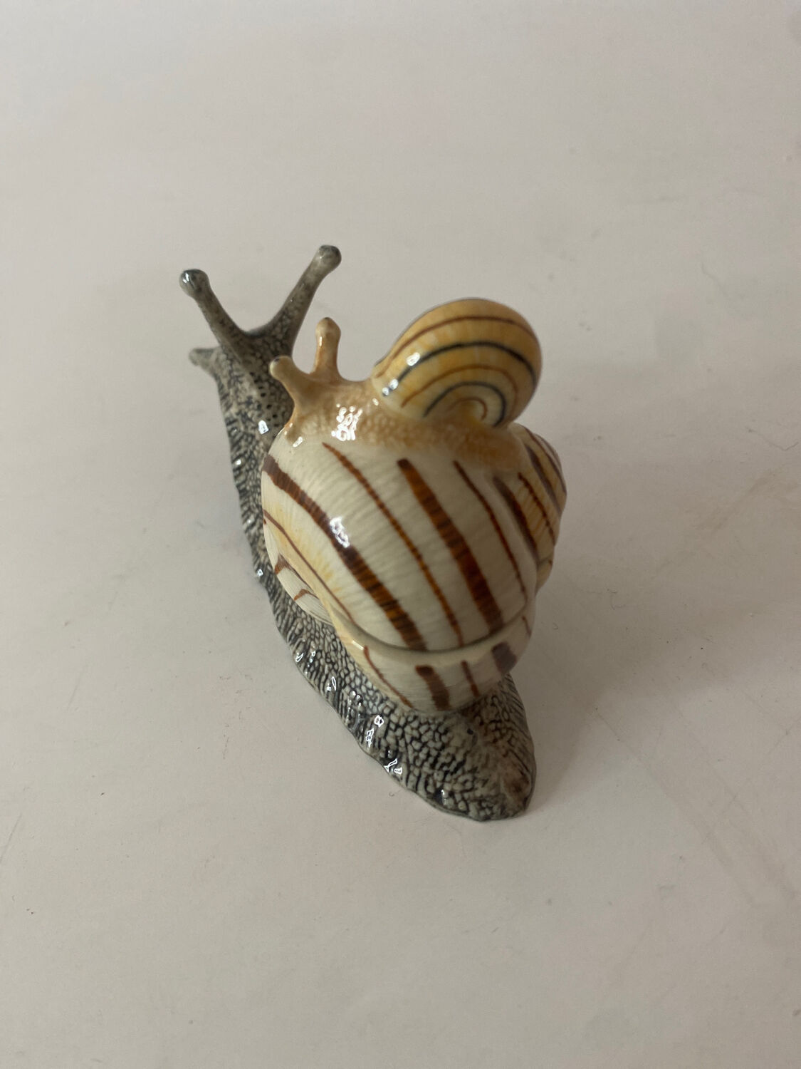 Porcelain figurine snail and its small