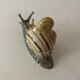 Porcelain figurine snail and its small