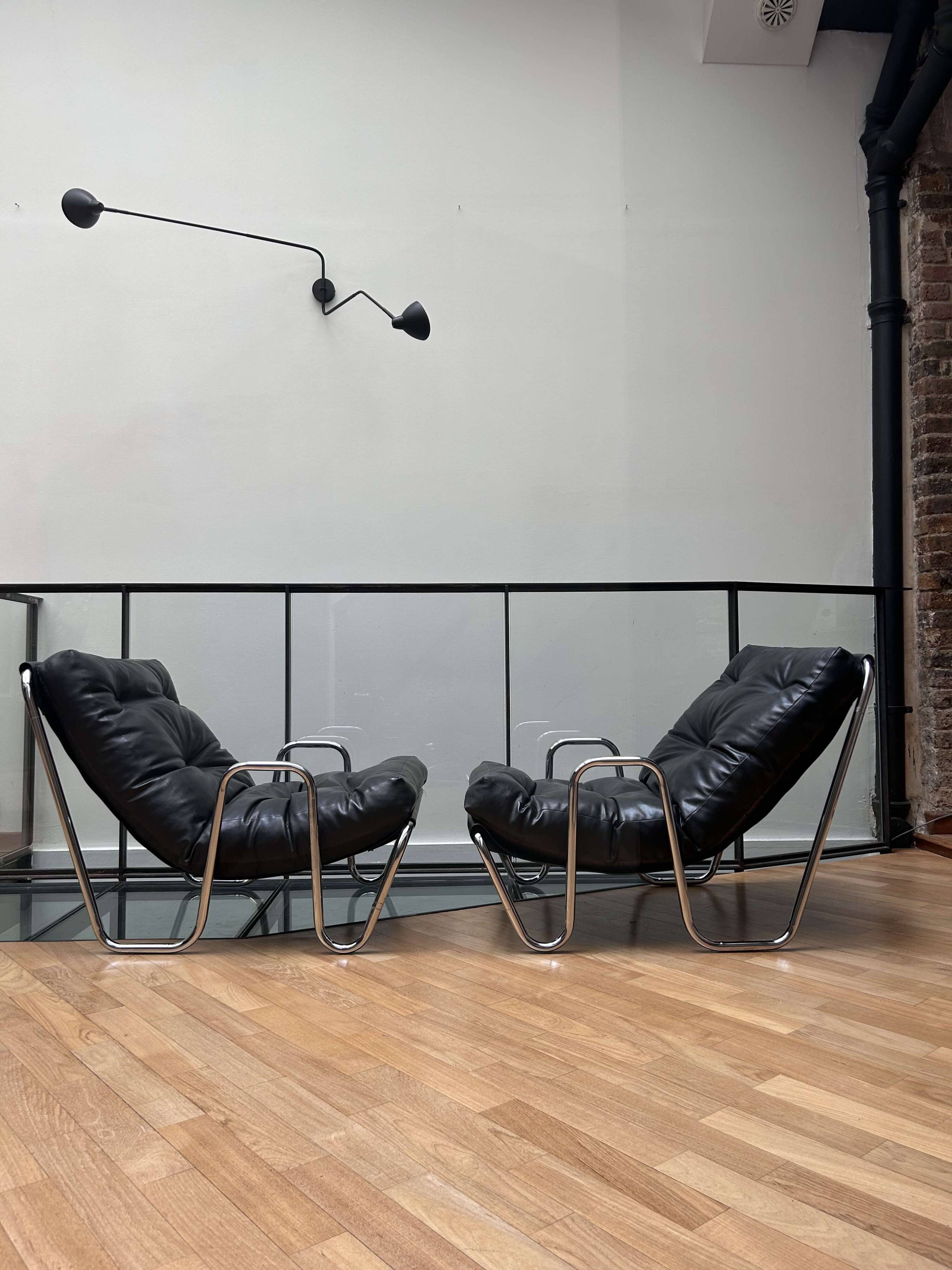 Pair of vintage armchairs in black imitation leather and chrome metal, France 1970