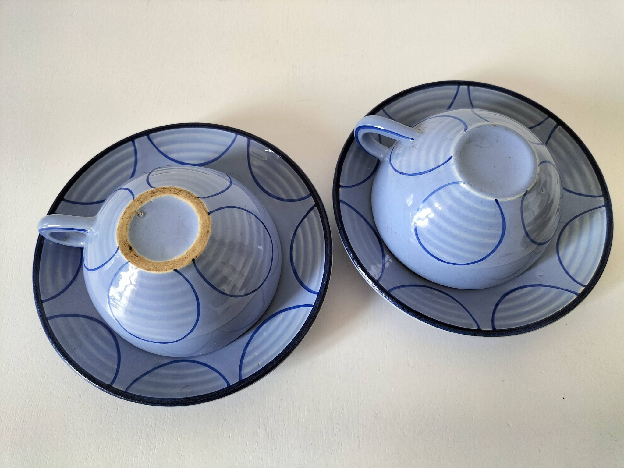 A pair of glazed ceramic cups and saucers from the 60s-70s.