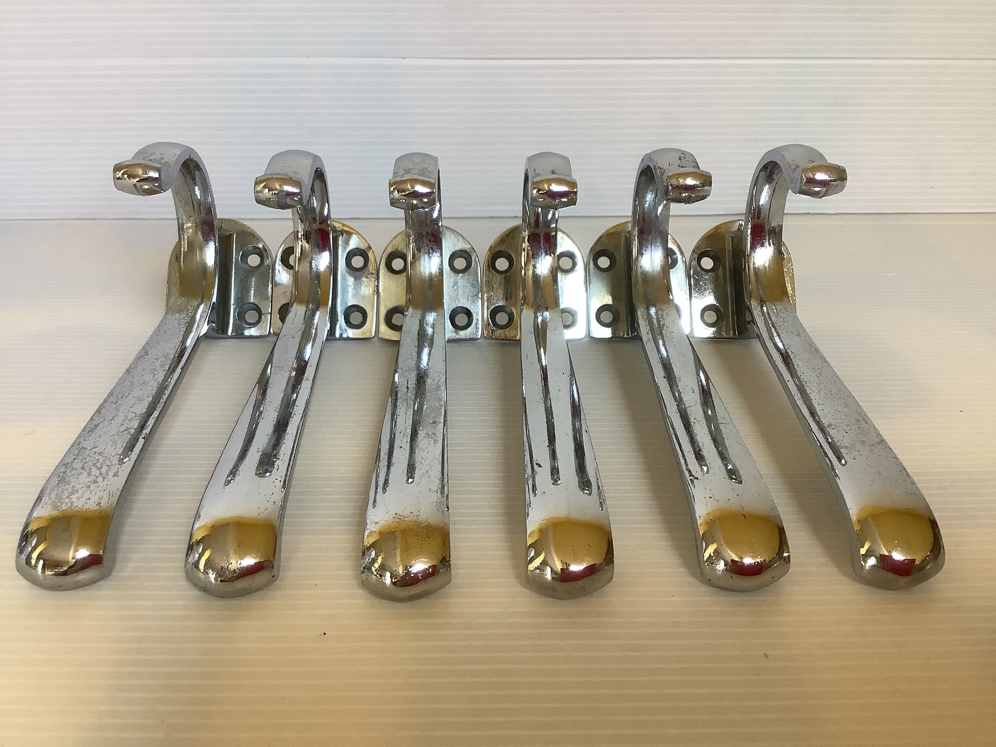 Six old chrome-plated metal hooks
