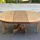 Round dining table with a central pedestal, stripped raw oak, 4 extensions, 19th century.