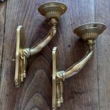 Pair of bronze wall sconces with outstretched arms and hands