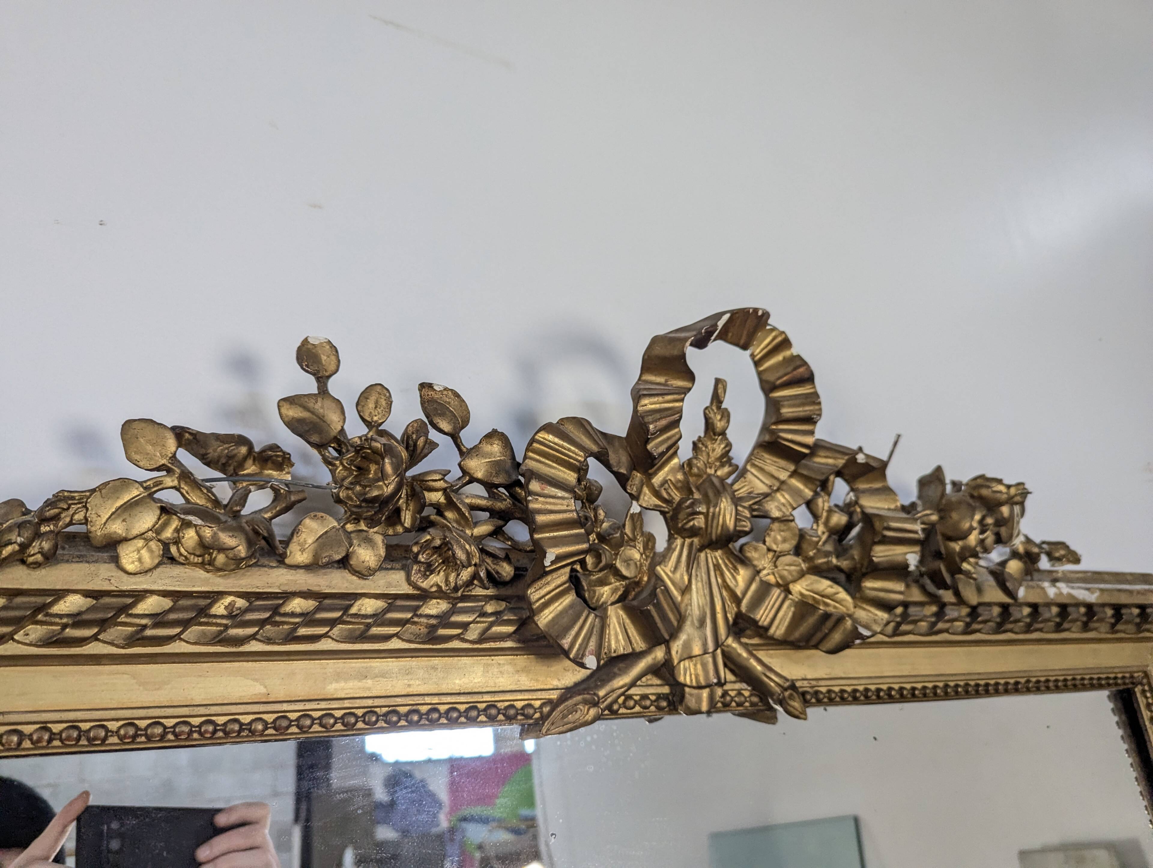 Golden Louis XVI style mirror with bouquet and shells.