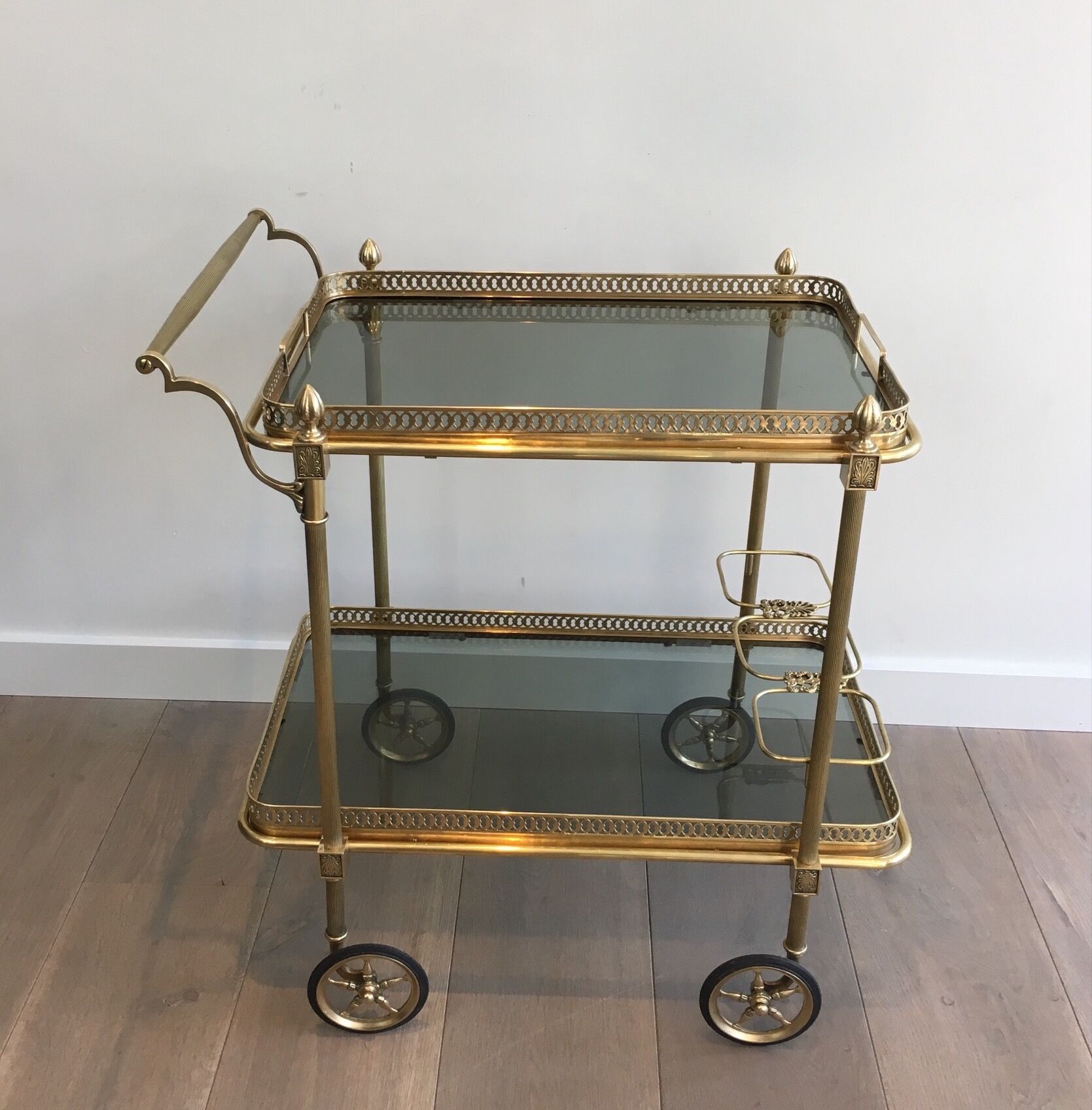 Neoclassical style rolling table in brass with blue glass tops