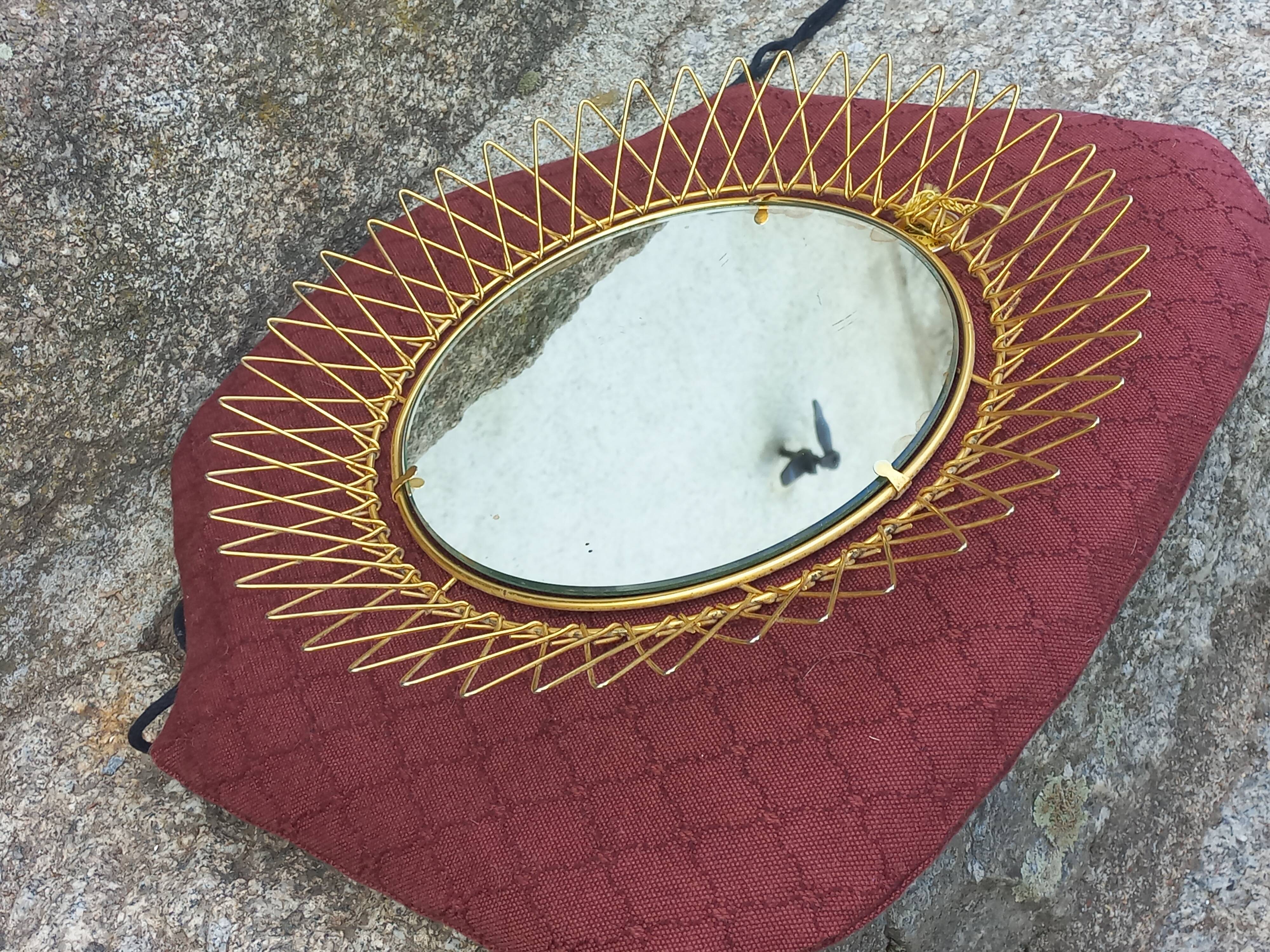 Vintage 1950s sun mirror in gold metal.